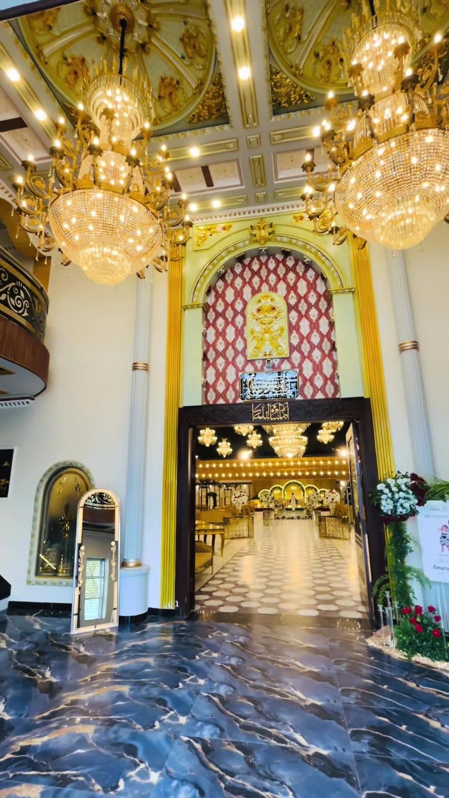 Grand foyer with crystal chandeliers and a marble floor at the doorway into the hall